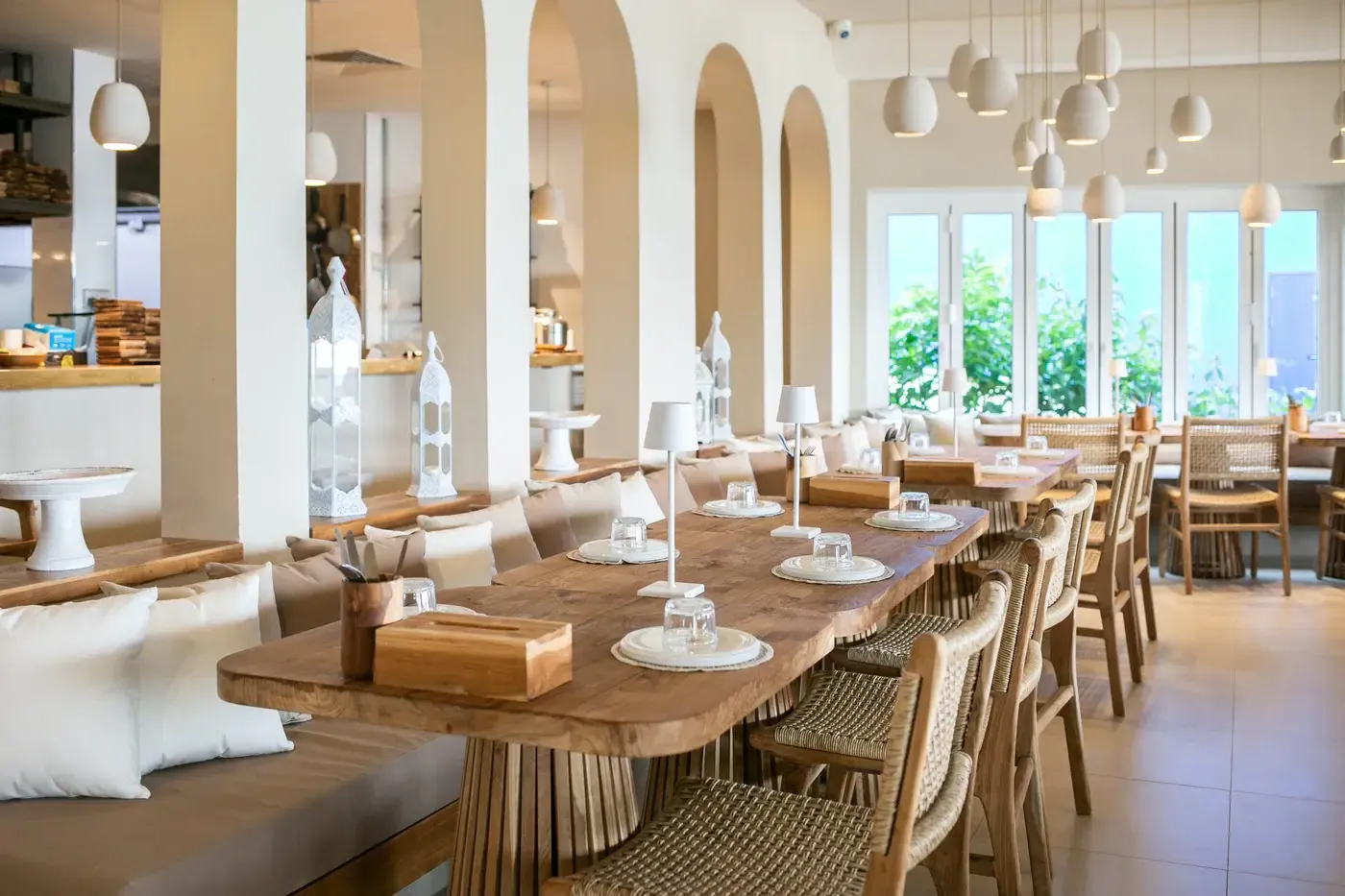 A luxurious bohemian dining room in Singapore featuring a live-edge wooden dining table, arched doorways, and elegant lighting.