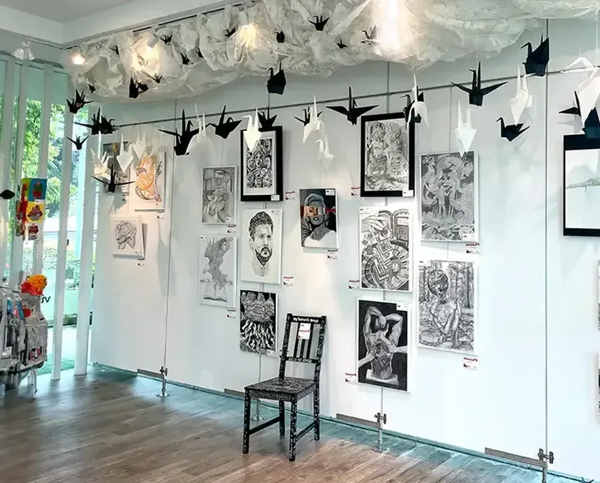 A modern art gallery interior in Singapore with black and white artwork displayed on a gallery wall with professional track lighting.
