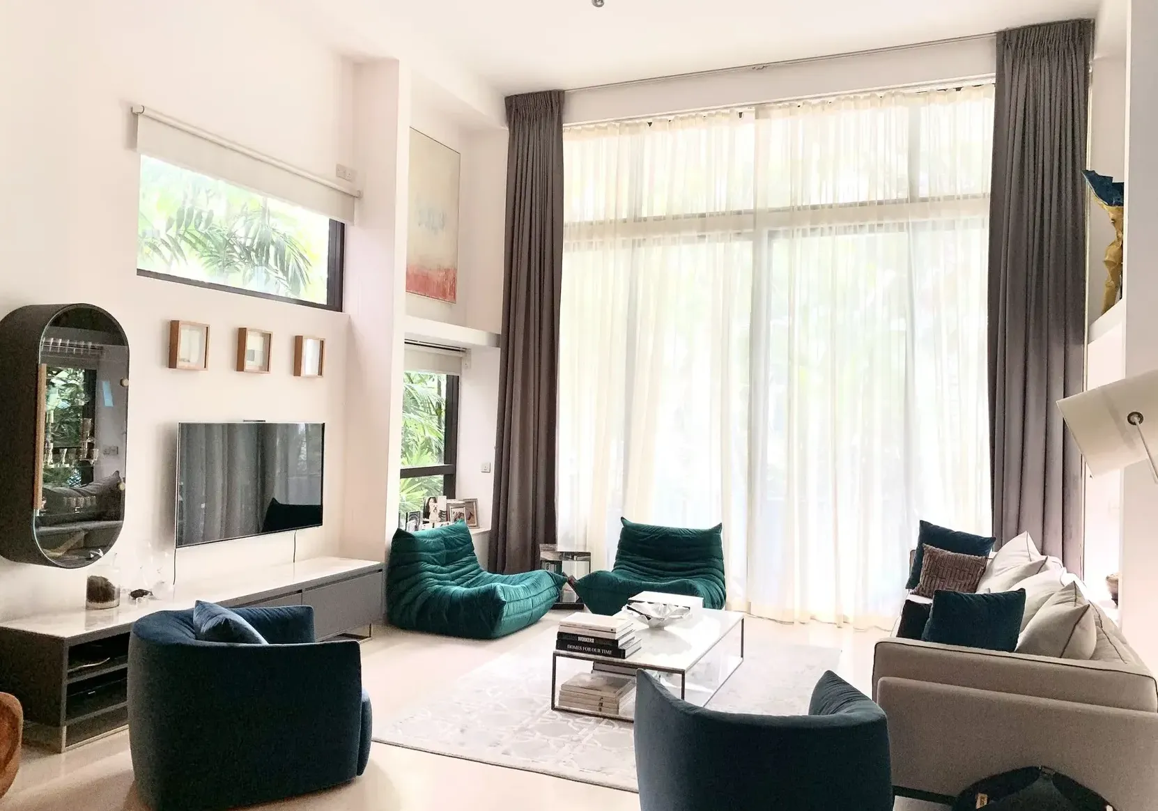 A modern luxury living room in Singapore with high ceilings, large windows, and an elegant seating arrangement.
