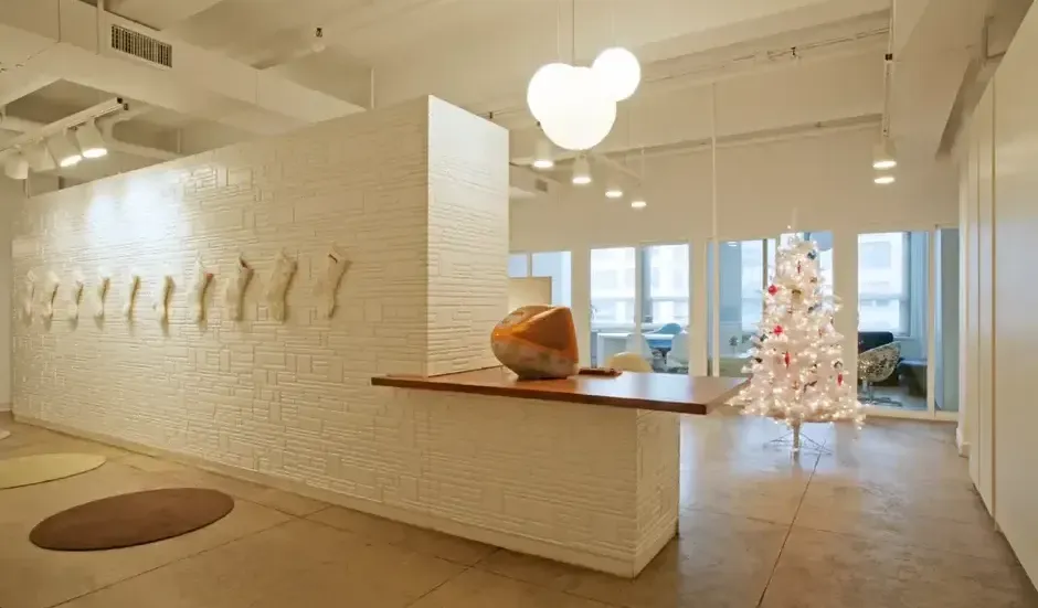 A modern luxury artistic commercial reception area with textured walls and a unique, sculptural pendant light.