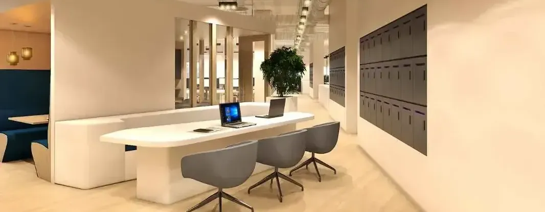 A bright and spacious modern office with a collaborative meeting table, ergonomic chairs, and creative wall decor.