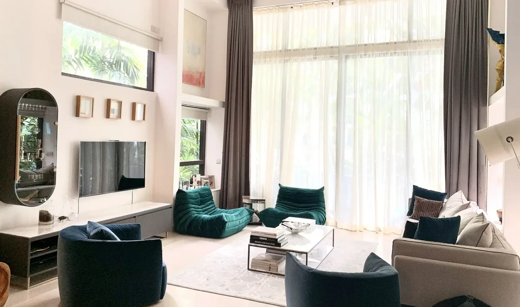 A modern luxury living room in Singapore with high ceilings, large windows, and an elegant seating arrangement.