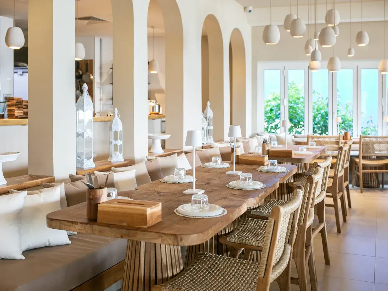 A luxurious bohemian Restaurant dining room in Singapore featuring a live-edge wooden dining table, arched doorways, and elegant lighting.