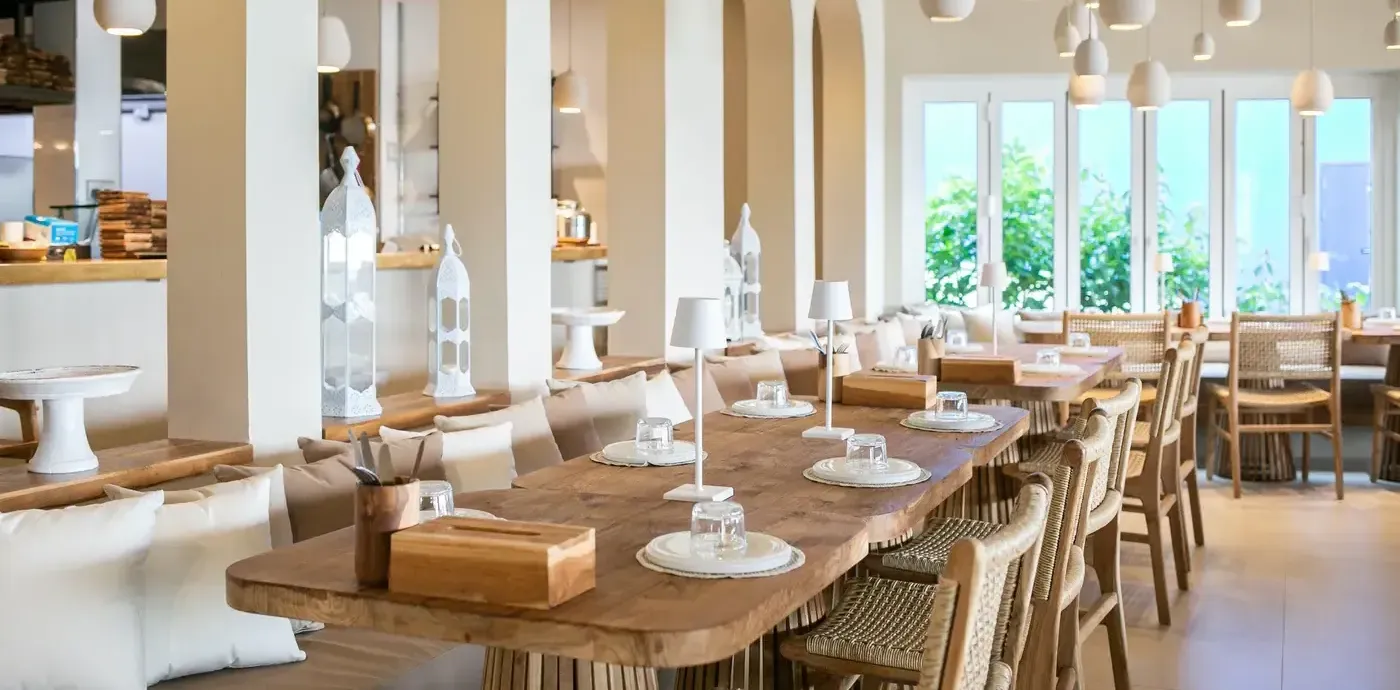 A luxurious bohemian dining room in Singapore featuring a live-edge wooden dining table, arched doorways, and elegant lighting.